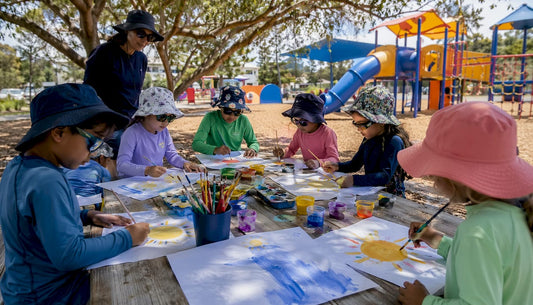 Children applying sunscreen outdoors in sun